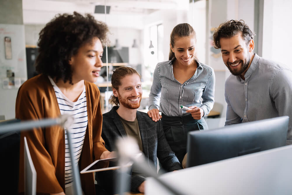 Team of IT people looking at computer